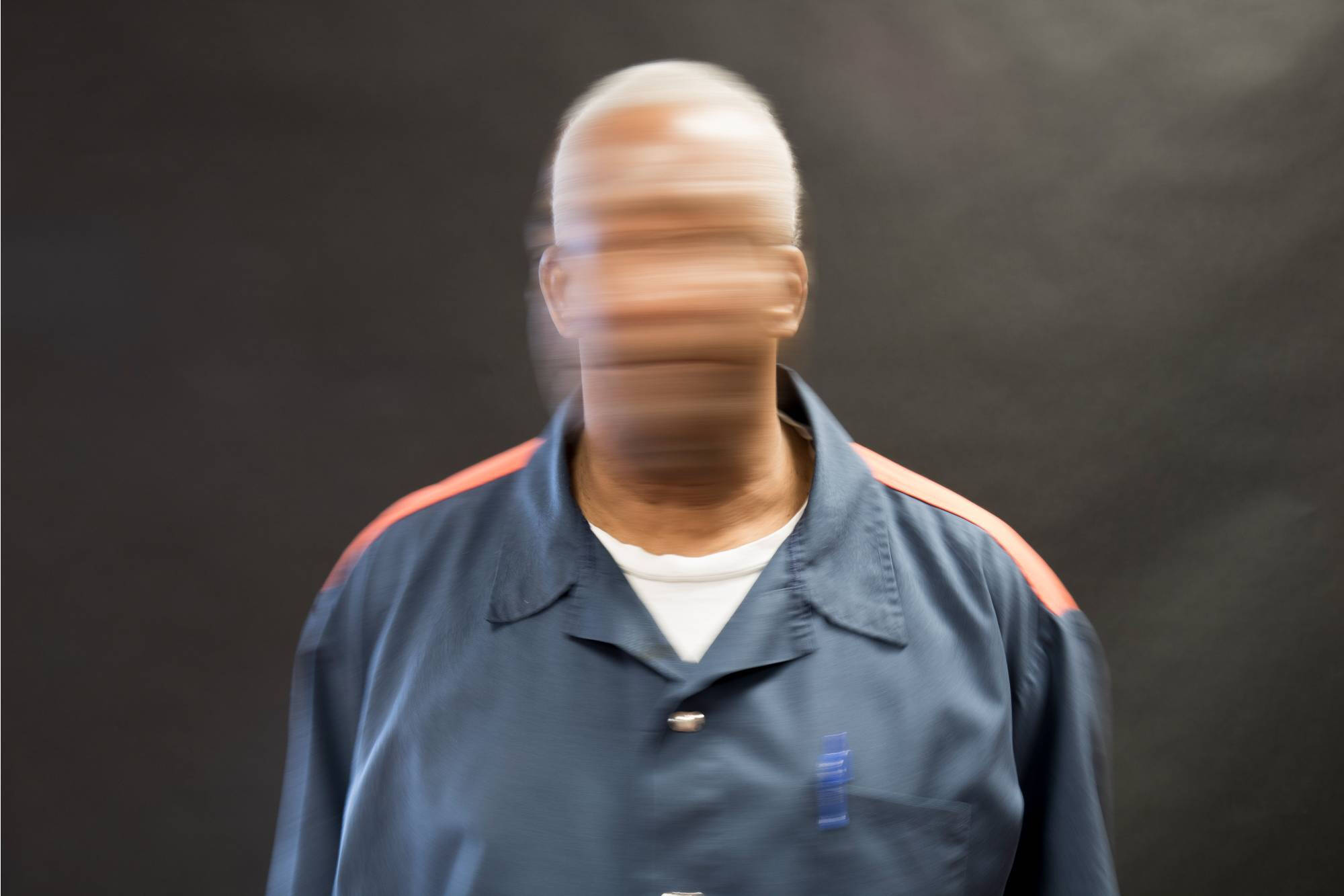 Man from the chest up, his face is blurry.